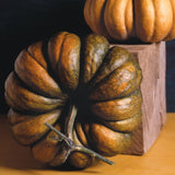 Close-up of a RARE Heirloom Organic Cinderella Pumpkin (Musquee De Provence Pumpkin, Fairytale pumpkin) on a wooden block with another pumpkin in the background.