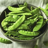 Heirloom Organic Mammoth Melting Snow Peas in a black bowl on a checkered tablecloth