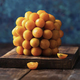Stack of Heirloom Organic Cape Gooseberry Seeds  Aka Physalis peruviana, Golden Berry, Rasbhari, Peruvian Groundcherry, Poha on a wooden cutting board with a blue background