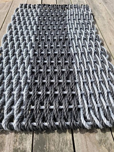 Textured rug on a dock by a body of water