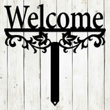 Decorative metal sign with 'Welcome' text on a wooden background