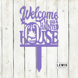 Purple decorative sign with 'Welcome to our Haunted House' text on a wooden background, featuring the Lewis Design Company logo.