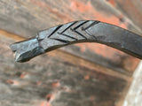 Close-up of a Dragon Fire Poker with engraved design on a blurred background