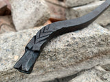 Black metal Dragon Fire Poker with decorative design on a stone surface
