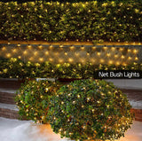 Decorative net bush lights illuminating a hedge and wall.
