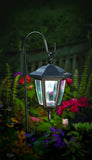 Solar-powered outdoor lamp with flowers in the background