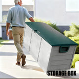A man in a light blue shirt and khaki pants carries a large outdoor storage box with a dark green top and white side panels in a sunny residential setting. The words 'STORAGE BOX' appear in bold text at the bottom right.