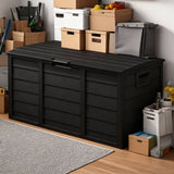 Black storage box with various items on a wooden floor