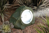 Solar garden light designed to look like a rock, surrounded by plants.