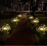Glowing outdoor lights arranged along a garden pathway at night.