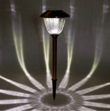 Solar-powered garden light casting a shadow on a dark background