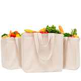 Three beige tote bags filled with fresh vegetables on a white background