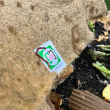 Small white label with green and brown design on a textured surface