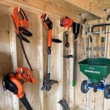 Gardening tools including a hedge trimmer, weed wacker, and cultivator against a wooden wall.