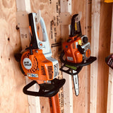 Two chainsaws mounted on a wooden wall