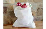 White reusable shopping bag with red onions against a stone wall background
