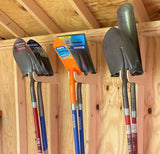 Set of shovels and hoes hanging on a wooden wall