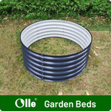 Circular garden bed with corrugated metal sides on grass, branded 'Olle Garden Beds'.