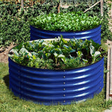 Two blue corrugated metal raised garden beds with green plants in a garden setting.