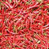 Close-up of red chili peppers with green stems.