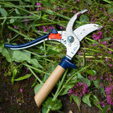 Opinel Hand Pruners Blue on a bed of green leaves and purple flowers