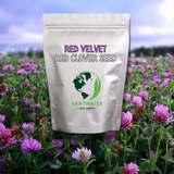 Bag of red velvet red clover seeds with Earthwise Seed Company logo against a field of purple flowers.