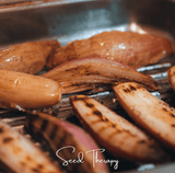 Grilled shallots on a grill with 'Seed Therapy' branding.
