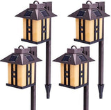 Four solar-powered outdoor lamps on white background
