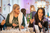 Two women at a product testing event with various items on a table.