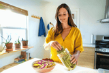 Woman in a yellow shirt preparing food in a kitchen
