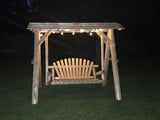 Wooden swing under a wooden arbor with lights at night