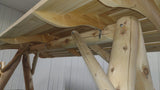 Close-up of a Swing Canopy for HD Swing with beams and a ladder against a white wall.