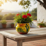Colorful vase with red flowers on a wooden table outdoors
