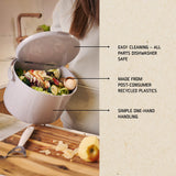 White compostable food waste bin with text highlighting features on a kitchen counter.