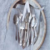Set of silverware on a wooden plate with a gray cloth background
