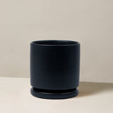 Black planter pot on a beige surface with a neutral background
