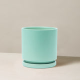 Turquoise planter with saucer on a beige background
