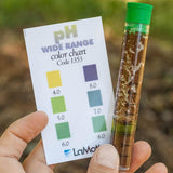 pH test kit with color chart held by a person outdoors