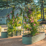Metal garden arch with climbing plants and pink flowers in a backyard setting.
