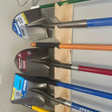 Set of Kobalt shovels on a wooden holder against a white wall.