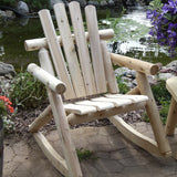 Wooden rocking chair in a garden setting with a pond and flowers.